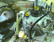 Figure 1.  The cracked gearbox with the casing crack indicated by the red arrow. The Ring-Front vibration RF-2 sensor is in the red circle shown as an orientation reference. A mirror was on the left hand side of the picture.